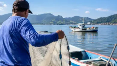 Pescador artesanal realiza atividade de pesca em embarcação
