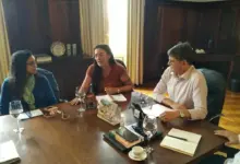 Três pessoas à mesa conversando