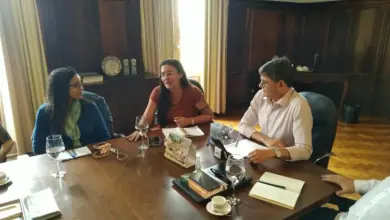 Três pessoas à mesa conversando