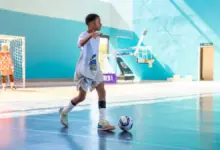 Estudante conduz a bola na partida de futsal