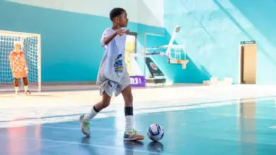 Estudante conduz a bola na partida de futsal