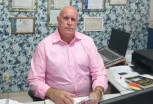 Candidato Dr. Helinho sentado à mesa