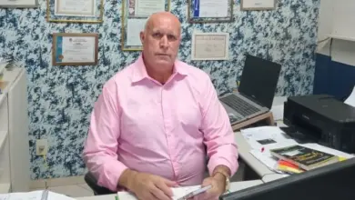 Candidato Dr. Helinho sentado à mesa