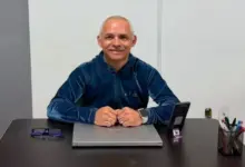 Marcelo Cunha sentado à mesa sorridente
