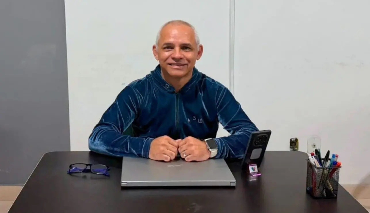 Marcelo Cunha sentado à mesa sorridente