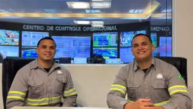 Dois irmãos gêmeos sentados à mesa sorrindo