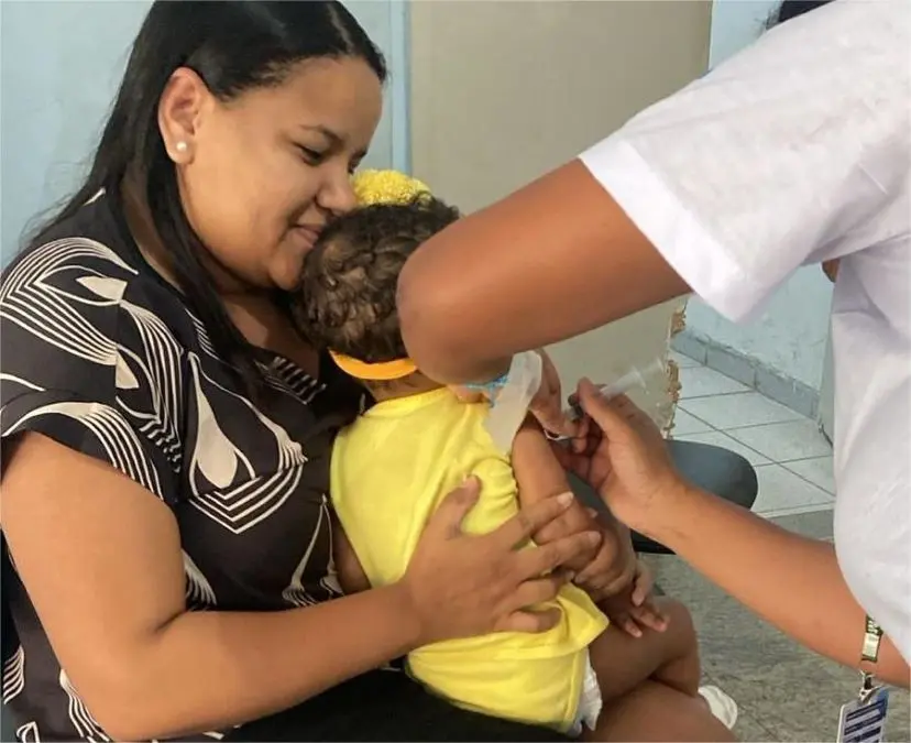 Mãe acompanha o filho durante a vacinação