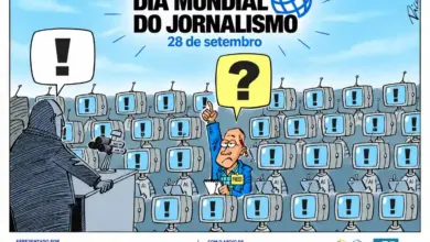 **Texto alternativo (Alt Text):** Cartune ilustrado em comemoração ao "Dia Mundial do Jornalismo – 28 de setembro". Em primeiro plano, à esquerda, uma figura sombria em tom cinzento fala num pódio com microfones, emitindo um balão de fala com um ponto de exclamação preto. Na plateia, uma multidão de robôs com cabeças em forma de monitores de televisão (alguns com as letras "AI" gravadas) repete a mesma mensagem, exibindo pontos de exclamação nas suas telas. No meio da multidão de robôs, destaca-se um único jornalista humano de terno azul, com um crachá onde se lê "PRESS", um bloco de notas na mão e um lápis atrás da orelha. Ele levanta a mão para fazer uma pergunta, emitindo um balão de fala amarelo com um ponto de interrogação. Na parte superior, lê-se o título "DIA MUNDIAL DO JORNALISMO - 28 de setembro" acompanhado por um ícone de um globo terrestre. Na parte inferior, constam os logotipos das organizações apoiantes, como WAN-IFRA, The Canadian Journalism Foundation, Project Kontinuum, MacArthur Foundation, ANJ, ANER e Atual.