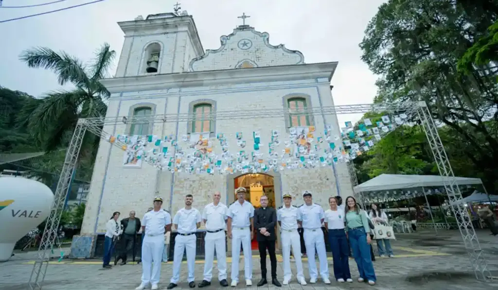 Igreja Nossa Senhora da Guia, em Mangaratiba, decorada para a festa da padroeira, com grupo de participantes em frente à entrada.