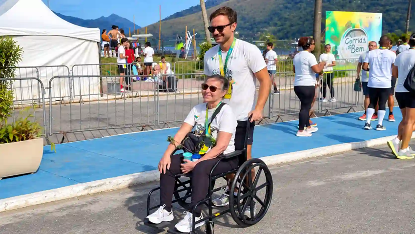 Ignez Brando, de 70 anos, em cadeira de rodas, ao lado do filho Iero de Paula, após participarem do percurso de 5 km da Corrida do Bem Eco, em Mangaratiba.