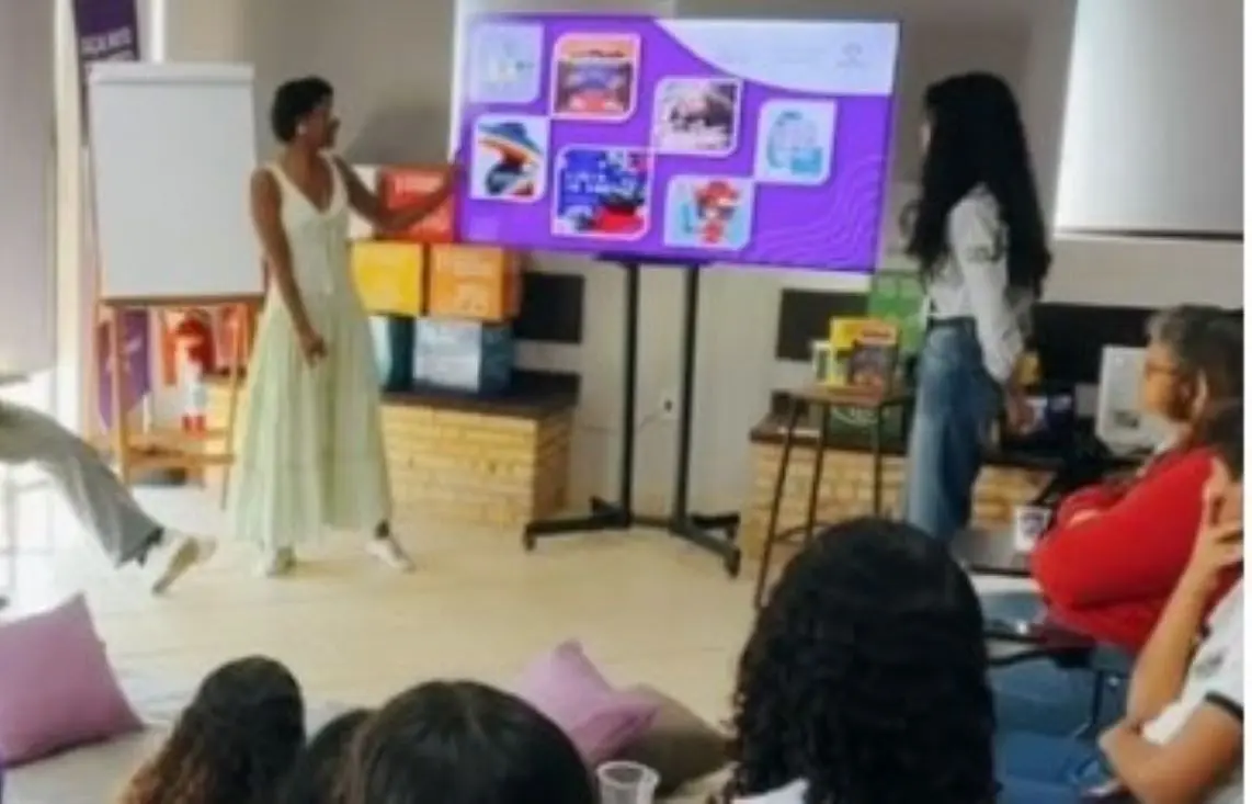 Professora dando aula observada por alunos