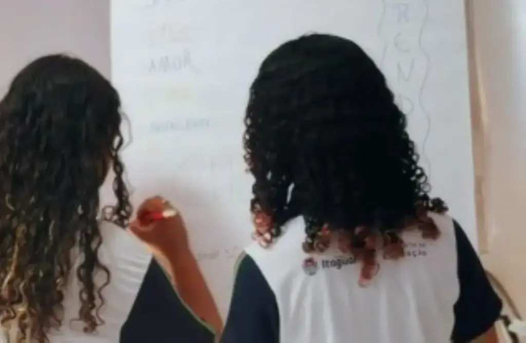 Duas estudantes escrevendo no quadro